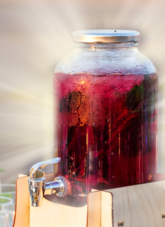 Fruit infuse water juice jar with tap. Fresh citrus juice in glass jar on Hotel restaurant table. Buffet catering service concept.の写真素材