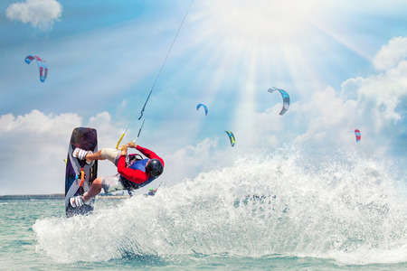 Kitesurfing. Man rides on kite on wavesの写真素材