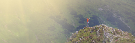 Tourist on the peak of high rocks. Sport and active life conceptの写真素材