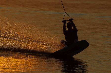 wakeboarder trains at sunset on the riverの写真素材