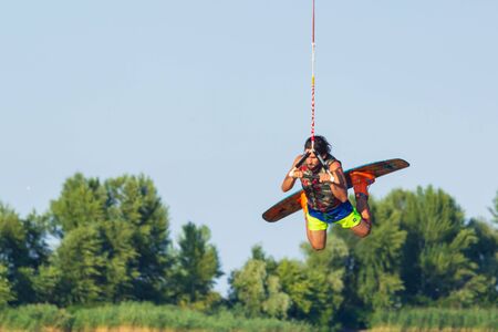 Cherkassy, Ukraine - July 19, 2019: Wakeboarder showing of tricks and skills at wakeboarding event...