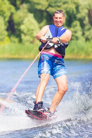 Cherkassy, Ukraine - July 19, 2019: Wakeboarder showing of tricks and skills at wakeboarding event...
