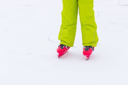 Red ice skates on frozen lakeの写真素材