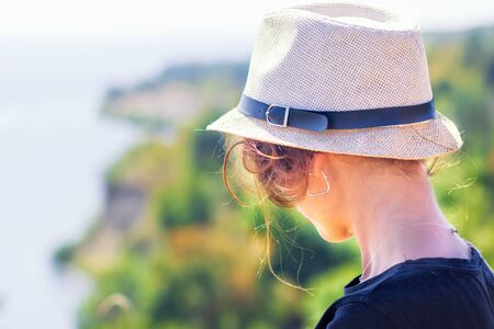 A woman looking to the sea in front of the beautiful sea sky and island viewの写真素材