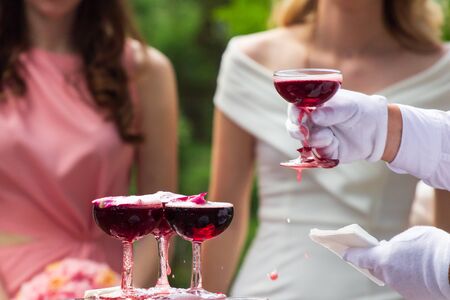 A pyramid of champagne glasses with a rose petals.