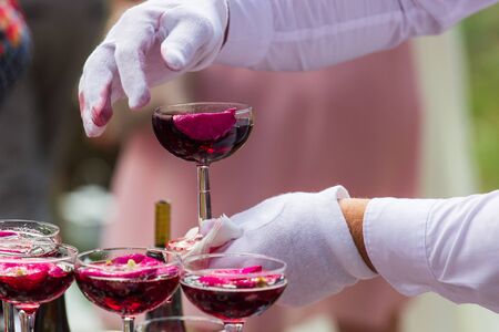 A pyramid of champagne glasses with a rose petals.