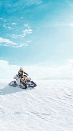 Man driving sports snowmobile in Finnish Lapland in a sunny day. verticalの写真素材