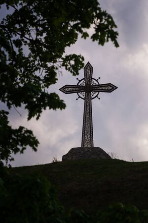 Iron cross and Kamianets-Podilskyi Castle, Ukraine.