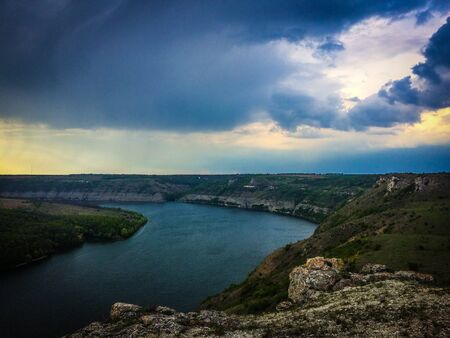 Panoramic view from the hill on bend of the river. Beautiful summer landscape. Colorful clouds of the morning sky. Dniester Canyon located at the territory of Dniester River Valley in Ukraine.の写真素材