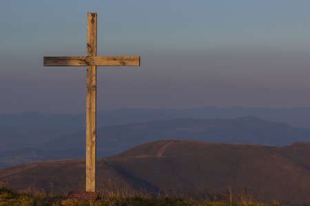 cross silhouette on the mountain at sunsetの写真素材
