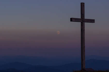cross silhouette on the mountain at sunsetの写真素材