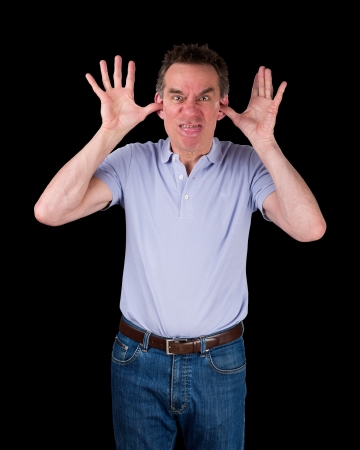 Angry Middle Age Man Poking Out Tongue with Hands in Ears Black Backgroundの写真素材