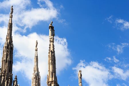 Statues on Milan Cathedral and blue skyの写真素材
