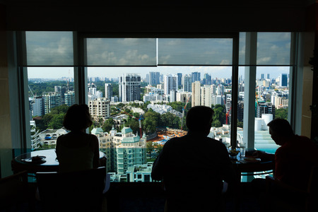 People having afternoon tea with view to the skyline of Singaporeのeditorial素材