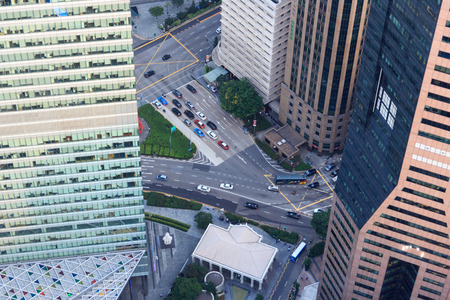 View downwards to the streets with cars between skyscrapers in Singapore
