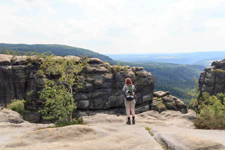 Female hiker looking at panorama from Affensteine in Saxon Switzerlandの写真素材
