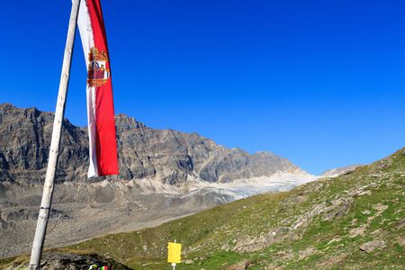 Mountain panorama with Austrian flag in Hohe Tauern Alps, Austriaの写真素材