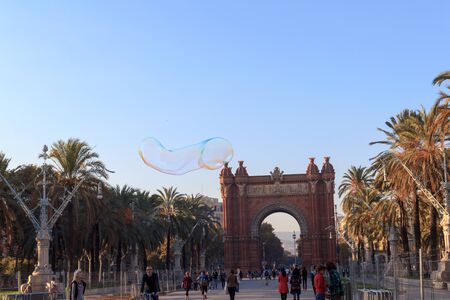 Soap bubble in front of Triumphal arch Arc de Triomf and promenade Passeig de Lluis Companys in Barcelonaのeditorial素材