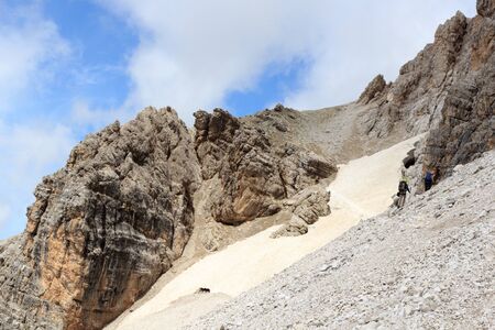 People climbing the Via Ferrata Severino Casara and snow field in Sexten Dolomites mountains, South Tyrol, Italyの写真素材