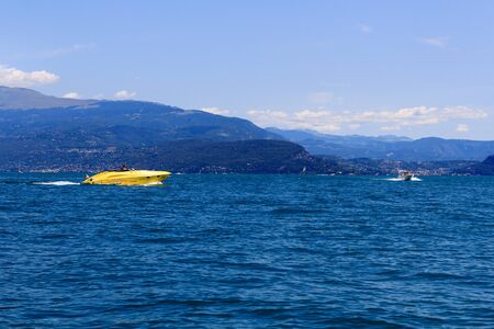 Motorboats boating on Lake Garda with mountain panorama, Italyのeditorial素材