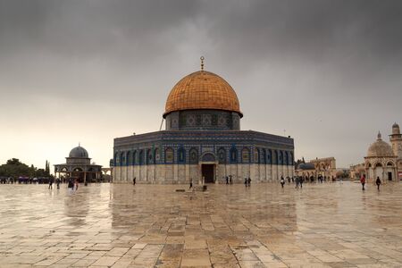 Islamic shrine Dome of the Rock with gold leaf and dark clouds on Temple Mount in Jerusalem Old...