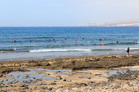 Group of tourists training practicing surfing with boards in holiday resort Playa de las Americas on Canary Island Tenerife, Spainの写真素材