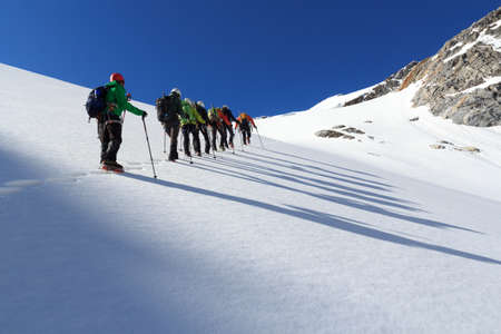 Rope team mountaineering with crampons on glacier Sexegertenferner towards Sexegertenspitze and...