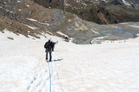 Rope team mountaineering with crampons on glacier Taschachferner and mountain snow panorama with...