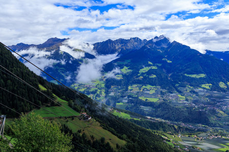 View from Hochmuth mountain station with panorama of summits Hirzer and Ifinger in the clouds in South Tyrol, Italyの写真素材