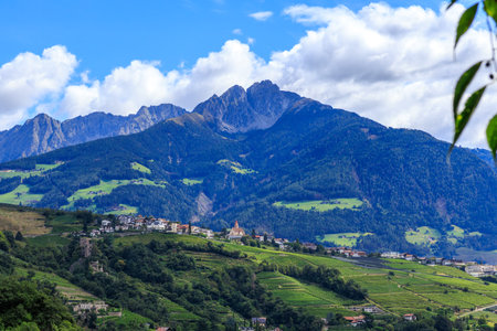 Panorama with castle Schloss Brunnenburg, vineyards, village Tirol (Dorf Tirol) and mountain summit Ifinger in South Tyrol, Italyの写真素材
