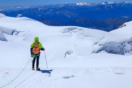 Mountaineer in rope team with crampons and mountain glacier panorama with summit Gran Paradiso in...