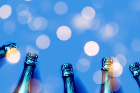 Champagne bottles on a blue background with bokeh lights Christmas, New Year, Bachelorette party festive backdropの写真素材