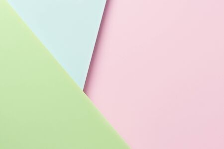 pink, blue and mint green paper sheets on top of each other with shadow and copy space