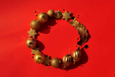 circle frame wreath of gold christmas ornaments on a red background perfect template for your xmas projectの写真素材