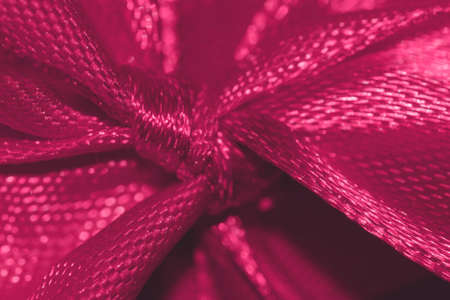 macro detail of raspberry sorbet color Christmas ribbon bow festive selective focus background