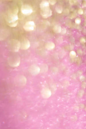 blurred bokeh background of pink and gold glitter festive shimy vertical backdropの写真素材