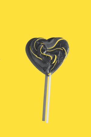 ultimate gray heart shape lollipop on a illuminating yellow backgroundの写真素材