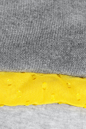 detail close up of stacked folded clothes with trendy colors illuminating yellow and ultimate gray fashion inspiration for 2021の写真素材