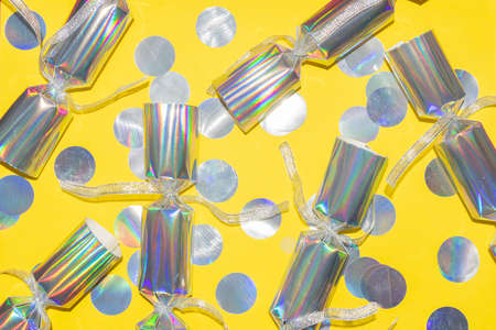 holographic party crackers with round confetti pattern on a yellow background for a festive card
