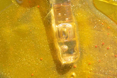 macro of pipette with liquid face serum on gold background luxury skin care treatment concept