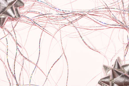 silver metallic star ribbon with tinsel on a pastel pink background for christmas backdrop