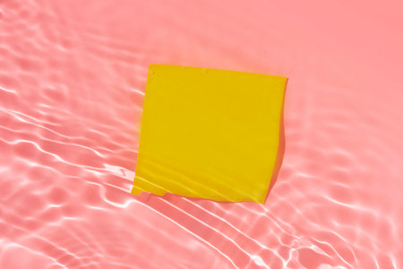 yellow sticky note in a pink water liquid background for your fun summer projectの写真素材