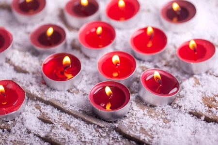red lit Tealights with golden flame in a church の写真素材