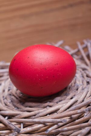 red easter egg in a wooden hay nest の写真素材