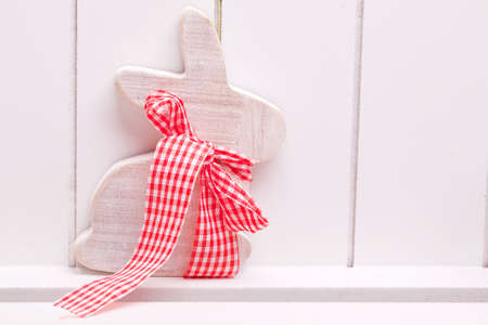 wooden easter decoration bunny with red white ribbon