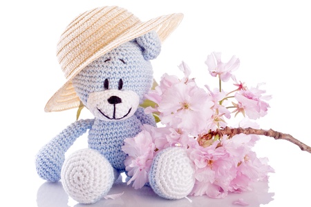 blue teddy bear stuffed animal with pink blossomの写真素材