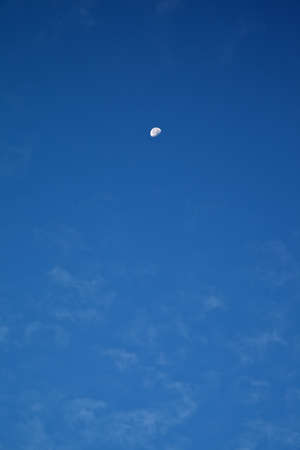 Blue sky with clouds and moon の写真素材