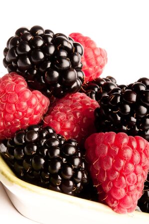 Blackberries and Raspberries on green dish isolated on white background