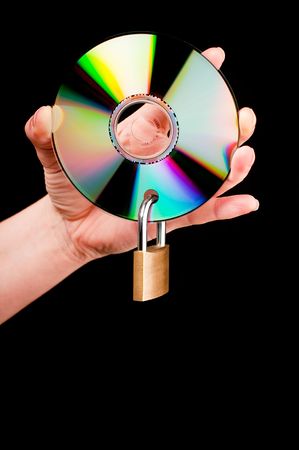 A hand holding a CD with a padlock on black backgroundの写真素材