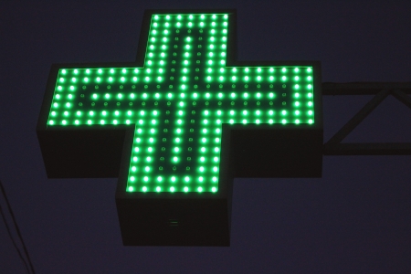 Neon green cross sign by nightの写真素材